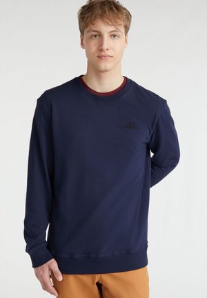 Mørkeblå sweatshirt lavet af en bomuldsblanding, med rund hals og ribbede manchetter, samt et diskret logo på brystet. Glat tekstur.