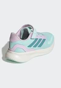 Tyrkysová športová obuv s fialovými detailmi a suchým zipsom. Vyrobená z priedušného sieťovinového materiálu, s ľahkou podrážkou so zrnitým protišmykovým povrchom.