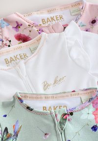 Tri otroške obleke s cvetličnimi in enobarvnimi vzorci. Značilnosti vključujejo mehke tkanine, naborke na izrezih in pastelne barve. Vidno je tudi logotip "BAKER".