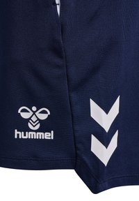 Marine træningsshorts lavet af tekstureret stof har et hvidt Hummel-logo og chevron-detaljer på siden, designet til sportsbrug.