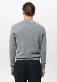 Maglione grigio a maglia con scollatura a girocollo classica, polsini e orlo a costine, caratterizzato da una texture liscia e morbida e una silhouette aderente.