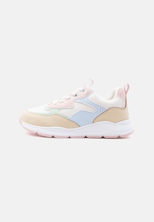 Witte sneaker met beige, roze, blauwe en mintgroene panelen, witte veters en een dikke witte zool op een lichtgrijze achtergrond.