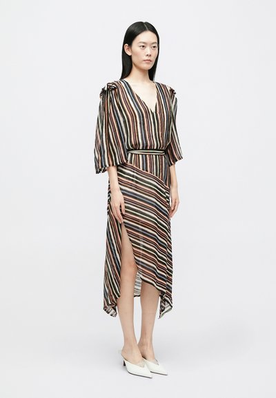 Svītrains apģērba kleita no viegla auduma, ar dziļu V-veida izgriezumu, īsām pūderveida piedurknēm un augstu šķēlumu, kombinēta ar baltām smailām kurpēm.