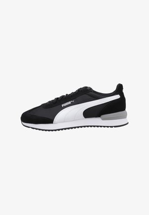 Sneaker in suede nero e tessuto con accenti bianchi, caratterizzato da un design elegante, chiusura con lacci e una suola texturizzata per una migliore aderenza.