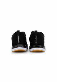 Svarta sportskor med en slät textilöverdel, som har en vit och gummisula. Inkluderar logotypdetaljer på svarta hälar.