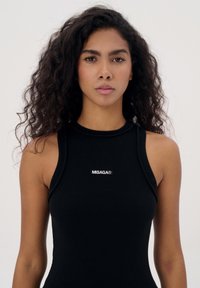 Zwarte geribde tanktop met een hoge hals, mouwloos ontwerp en een witte logo "MISAGA®" op de borst.