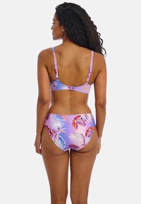 Biquini de mujer con una base lila y coloridos patrones florales tropicales. Tirantes ajustables y cierre de gancho en la parte posterior.