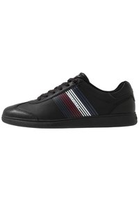 Zwarte sneaker met een soepele leren bovenkant, voorzien van horizontale strepen in rood, wit en blauw. Rond teen en vetersluiting. Rubineren zool.