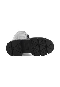 Must musta tallal, millel on raske profiiliga tall, lisaks sile ülemine osa dekoratiivse õmblusega ja lame, tekstureeritud haardepind.