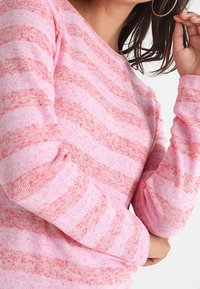 Langärmliger Pullover aus weichem, rosa Strick mit dunkleren rosa horizontalen Streifen. Mit Rundhalsausschnitt und gerippten Bündchen.