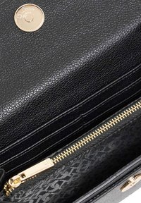 Black leather wallet featuring a textured surface, gold hardware, and a zippered compartment with a patterned interior.