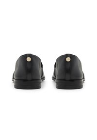 Scarpe in pelle nera con suola piatta, dotate di un piccolo logo sul retro e una finitura liscia. Design a punta arrotondata, stile minimalista.