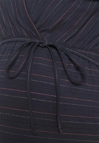 Mörkblå klänning med subtila vertikala ränder i röd och metalltråd, med en samlad midja och ett knytbart tygbälte.