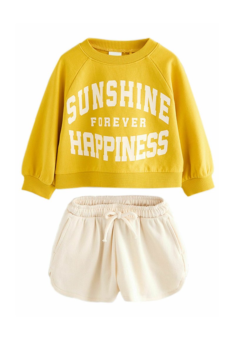 Gelbes Sweatshirt mit dem Text "SUNSHINE FOREVER HAPPINESS" in Weiß, kombiniert mit cremefarbenen Shorts mit elastischem Bund und Kordelzug.
