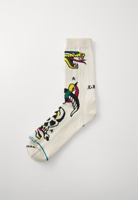 White ankle sock featuring colorful designs of a dragon and a skull, with additional patterns and accents in red, yellow, and blue.