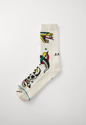 White ankle sock featuring colorful designs of a dragon and a skull, with additional patterns and accents in red, yellow, and blue.