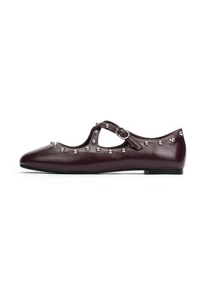 Zapato plano de cuero burdeos con punta redonda, tira de tobillo, tachuelas plateadas en el borde y una textura suave.