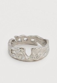 Ασημένιο δαχτυλίδι με υφή, ακανόνιστη επιφάνεια και κομμένα σχήματα, με ελαφρώς ανοιχτό σχέδιο στεφάνης σε απλό λευκό φόντο.