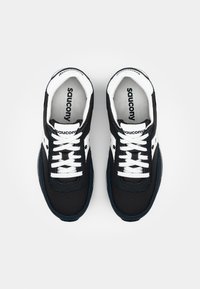 Čierno-biele športové topánky s režným a koženým vrchom, okrúhlou špičkou a bielymi šnúrkami. Obsahujú logo Saucony na jazyku a stielkach.