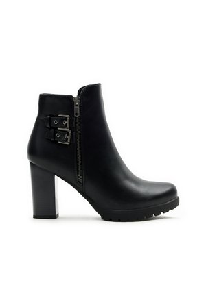 Bota de cuero negro hasta el tobillo con punta redonda, un tacón alto de bloque, cremalleras laterales y dos hebillas metálicas decorativas en el lado exterior.