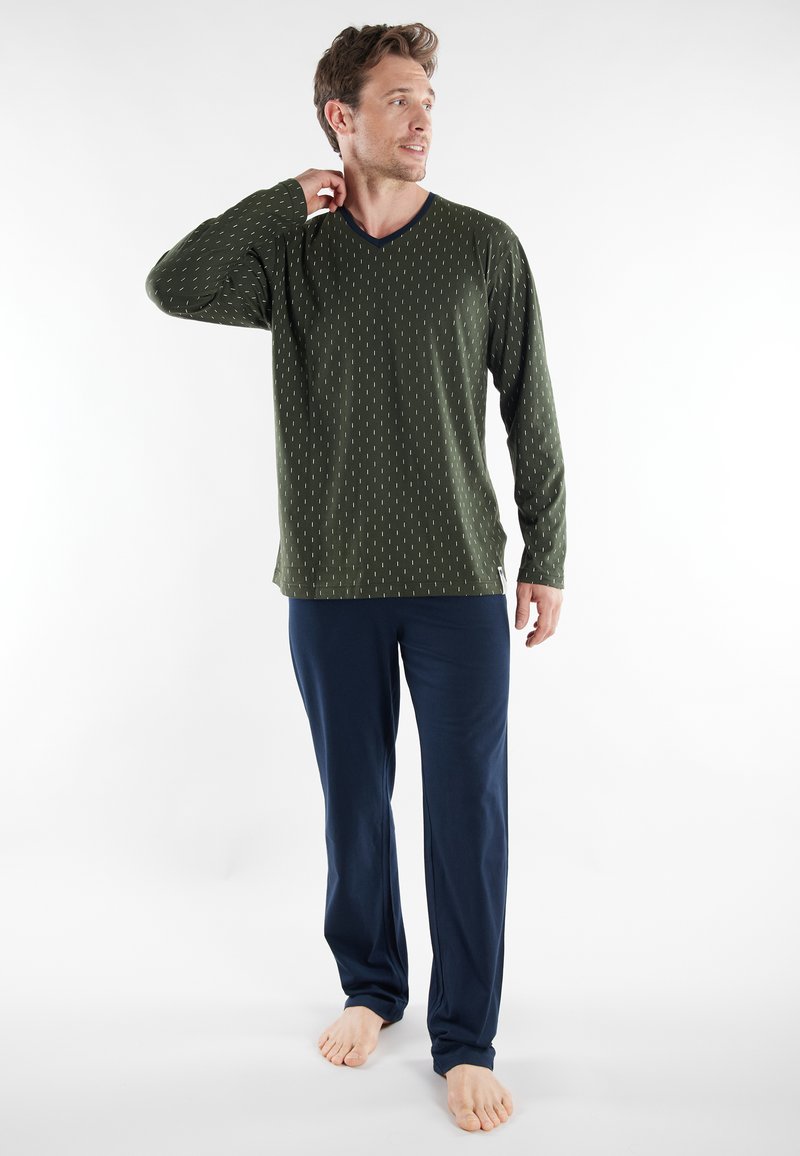 Green long-sleeve V-neck shirt with white vertical stripes, paired with navy blue loose-fitting pants. Soft fabric, relaxed silhouette.