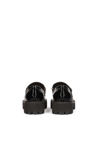 Black patent leather sandals with a thick, textured rubber sole, featuring a strap and buckle detail. Back view displays the rounded heel.