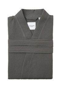 Peignoir de bain grisonnant en tricot gaufré, plié soigneusement, avec un col châle et une ceinture nouée, présentant une texture brodée et une étiquette de marque visible.