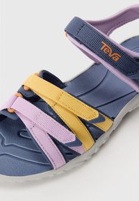 Teva-sandaler med blå, lavendel- och gula remmar. Texturerad gummisula med justerbara remmar för en säker passform.