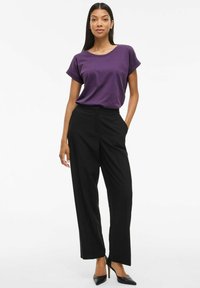 Lila kortärmad T-shirt kombinerad med högmidjade svarta vida byxor och svarta stilettklackar, med en slät textur och rena linjer.