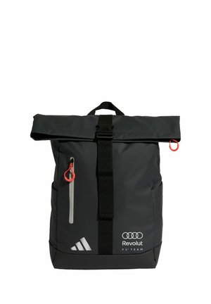 Sac à dos noir à fermeture roulante avec sangle frontale, poche zippée avec tirette rouge, logos Adidas et Audi Revolut F1 Team sur la partie inférieure avant.