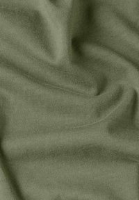 Soft, olive green fabric with fine knit texture, showing natural folds and slight shadows.