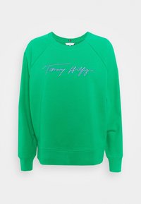 Sweatshirt vert en coton avec un col rond. Présente des manches raglan et un logo "Tommy Hilfiger" en strass sur la poitrine.