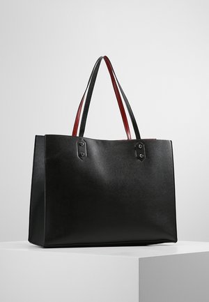 Zwarte rechthoekige totebag met dubbele schouderbanden, voorkant toont zwarte buitenkant en rode binnenkant van de banden, op witte ondergrond.