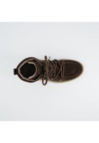 Bottine en suède marron avec un col rembourré, des lacets plats et une semelle en caoutchouc. L'intérieur présente un revêtement doux pour le confort. Vue de dessus.