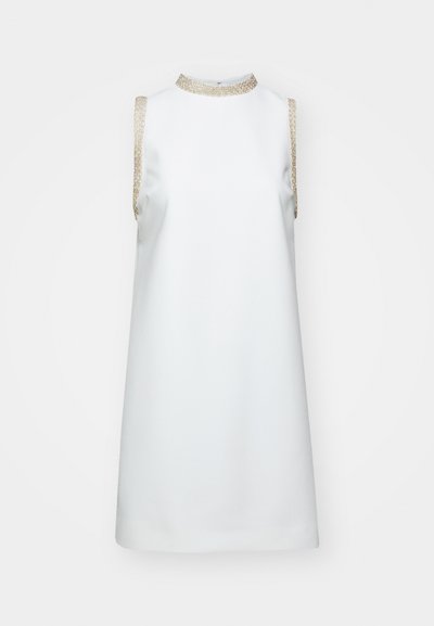 Fehér ujjatlan ruha, magas nyakkivágással, aranyszínű fémes díszítéssel a vállakon, sima textúrával és A-vonalú szabással.