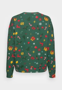 Grön fleece-tröja med ett festligt tryck av renar, presenter, stjärnor och godispinnar i röd, gul och vit mot en texturerad bakgrund.