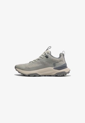 Light grey hiking shoe with mesh and synthetic upper, textured detailing, thick beige midsole, and rugged black rubber outsole.