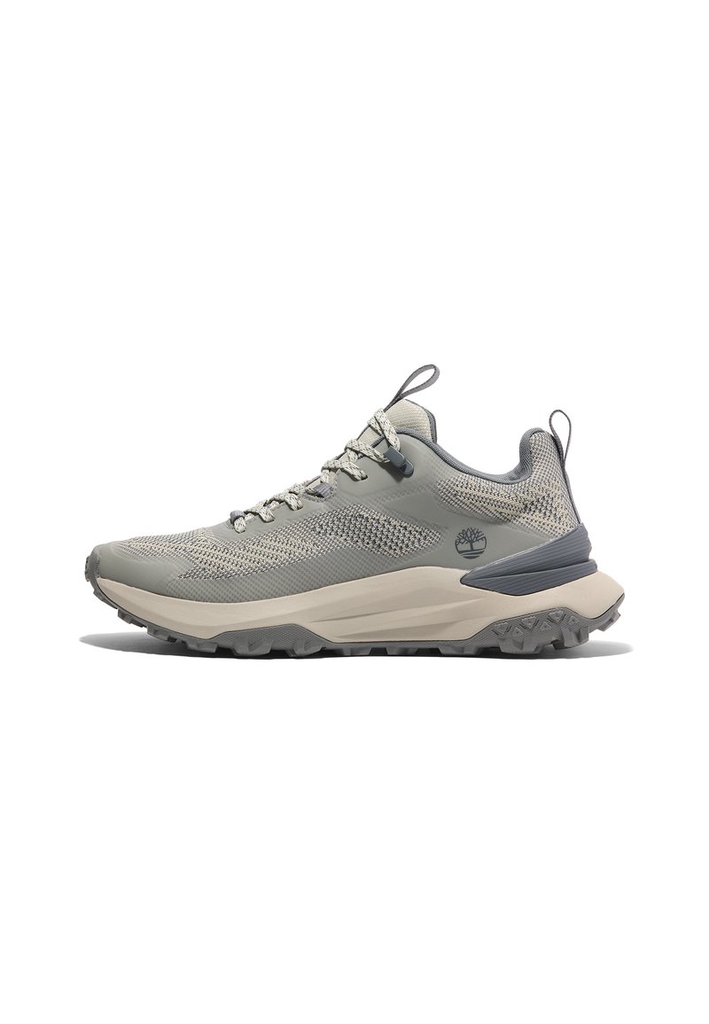 Zapatilla de senderismo en gris claro con parte superior de malla y sintético, detalles texturizados, entresuela gruesa en beige y suela exterior de goma negra resistente.