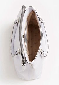 Hvid lædertaske med lynlåslukning, indvendig lomme og beige foring med et gentagent mønster. Sølvfarvet metalhardware.