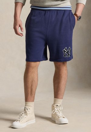 Marineblå shorts med elastik i taljen og stribet detalje, med hvidt broderet logo. Blødt materiale og opsmøgede kanter.