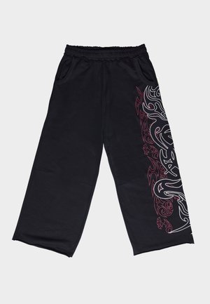 Μαύρο παντελόνι φαρδιάς γραμμής από απαλό ύφασμα. Διαθέτει λευκό και κόκκινο φυλετικό σχέδιο στο αριστερό πλευρό, με ελαστική μέση και τσέπες.