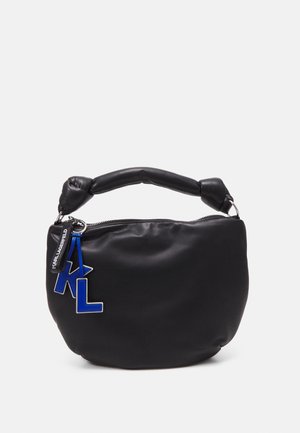 Sac à main noir en cuir souple avec poignée rembourrée et breloques bleues en forme des lettres "K" et "L" suspendues à la fermeture éclair.