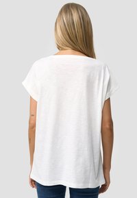 Witte katoenen T-shirt met korte opgerolde mouwen, een losse pasvorm en een afgeronde zoom, van achteraf weergegeven. Glad textuur, minimalistisch ontwerp.