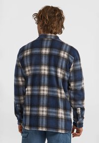 Blauw en zwarte geruite flanellen shirt met witte accenten, lange mouwen en knoopmanchetten; zachte textuur en een kraagontwerp.