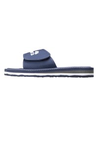 Niebieskie klapki wsuwane z tkaninowym wierzchem, regulowanym paskiem na rzep oraz teksturowaną podeszwą. Posiadają białe logo na pasku i warstwowy design podeszwy.