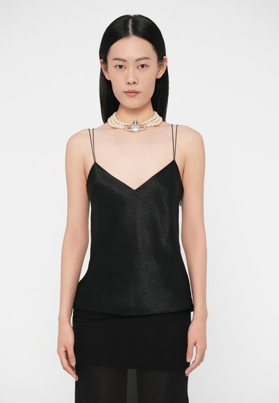 Black silk camisole with thin straps, V-neck design, textured fabric, paired with layered pearl necklace featuring a decorative clasp.