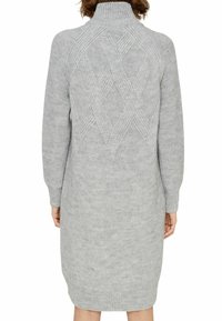 Robe pull gris tricotée avec un col montant, des manches longues, et un motif losange texturé dans le dos, avec des poignets et un ourlet côtelés.
