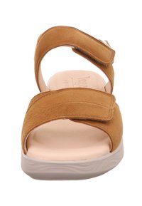 Tan-Suede-Sandale mit verstellbaren Riemen, offener Zehenpartie, beiger Innensohle und weißer strukturiertem Sohle. Verfügt über eine minimalistische und leichte Konstruktion.