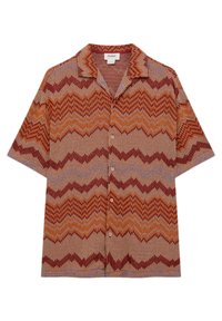 Chemise à manches courtes boutonnée avec motif zigzag multicolore dans des nuances de marron, orange et violet, comprenant un col et des boutons clairs.