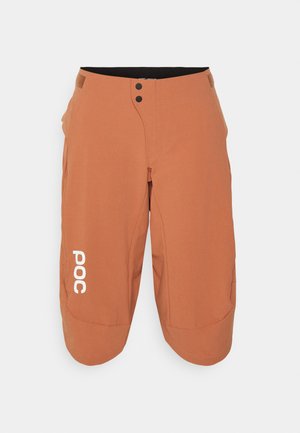 Shorts da ciclismo arancioni con vestibilità morbida, realizzati in tessuto leggero. Presentano una chiusura con bottone frontale e un logo bianco sulla coscia sinistra.